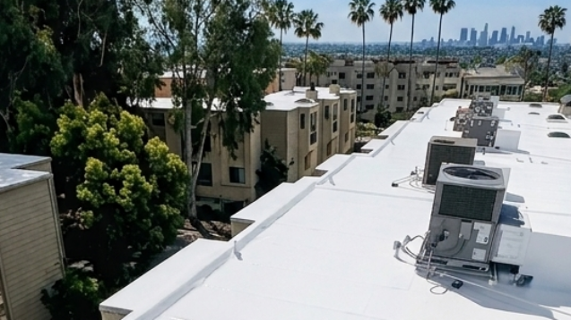 White commercial flat roof restored with silicone coating near Long Beach skyline